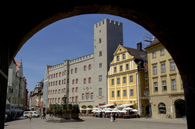 Buildings by street in city against sky