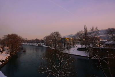 High angle view of river amidst buildings against sky at sunset