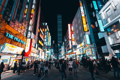 People walking on city street at night