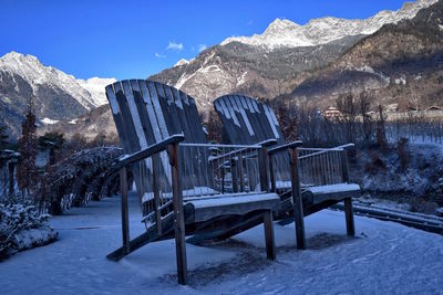 Empty chairs on snowed landscape