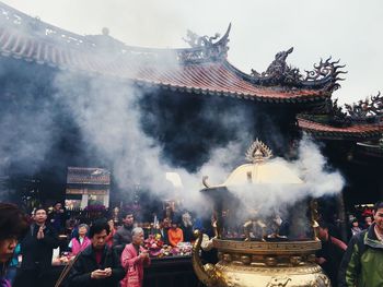 Group of people outside temple against buildings