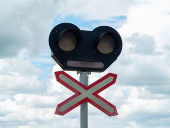 Low angle view of road sign against cloudy sky