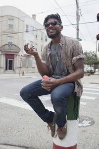 A young man sitting and eating frozen yoghurt.