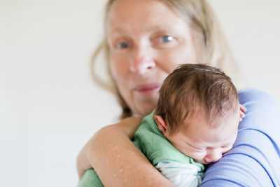 Portrait of grandmother carrying baby grandson