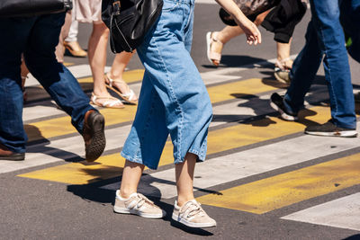 Low section of people walking on crosswalk