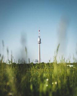 Communications tower on field against clear sky