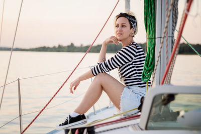 Pretty woman relaxing on the nose of the yacht at a sunny summer day