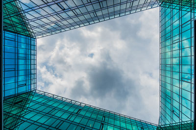 Low angle view of glass building against sky