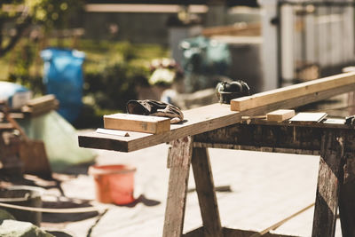 Wooden planks and gloves in yard during sunny day