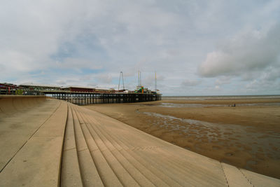 Pier on beach against sky