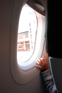 Close-up of child hand by airplane window