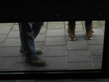 Low section of man standing on tiled floor