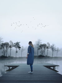 Rear view of woman walking on water against clear sky