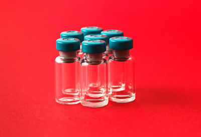 Close-up of drinking glass against red background