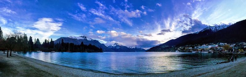 Panoramic view of lake and mountains against blue sky