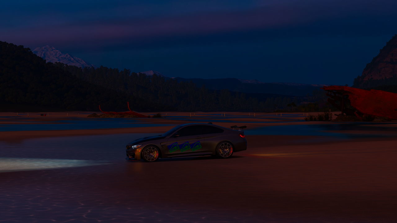 VINTAGE CAR AGAINST MOUNTAIN RANGE AT SUNSET