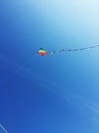 Low angle view of kite flying against blue sky