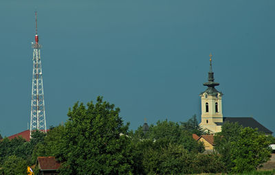 Low angle view of trees and building against sky