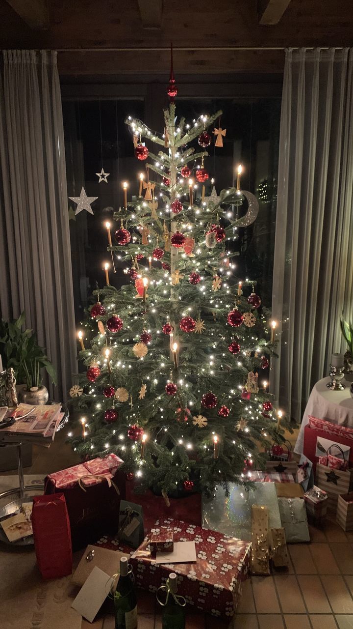 ILLUMINATED CHRISTMAS TREE AT HOME DURING NIGHT