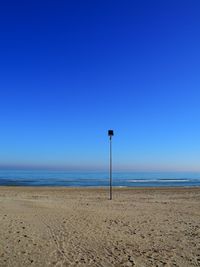 Scenic view of beach against clear blue sky