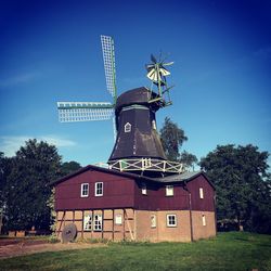 Traditional windmill on field against sky
