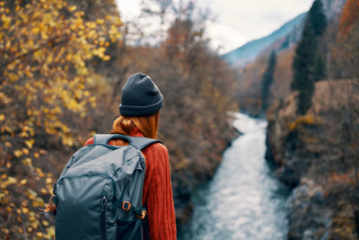 Rear view of woman standing on road during autumn