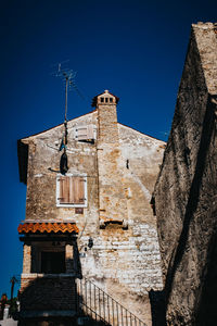 Low angle view of old building against clear blue sky