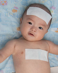 Portrait of cute baby girl lying on bed