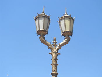 Low angle view of street light against blue sky