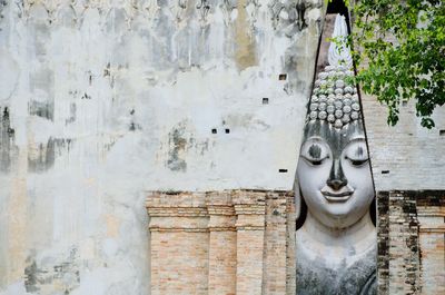 Giant buddha statue seen through wall at sukhothai historical park