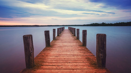 Wooden pier over sea against sky