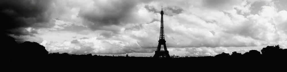 Low angle view of silhouette buildings against cloudy sky