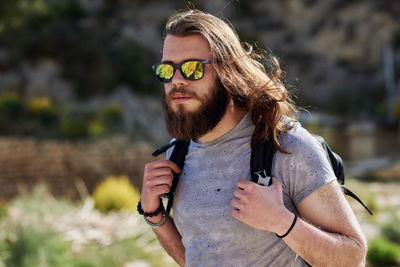 Young man wearing sunglasses walking outdoors