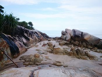 Scenic view of rocks on beach against sky