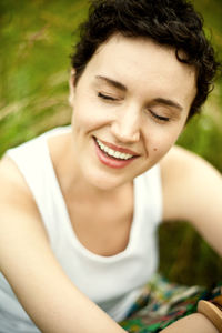 Closeup portrait of happy cute girl on green field