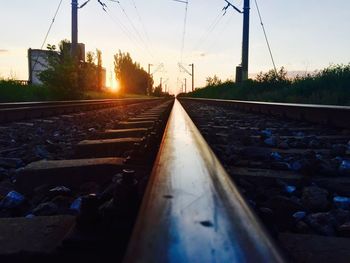 Railroad tracks against sky during sunset