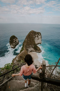 Rear view of woman looking at sea against sky