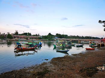 Boats moored in river against sky