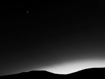 Low angle view of silhouette mountain against sky at night