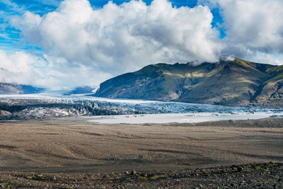 Scenic view of landscape against cloudy sky during winter