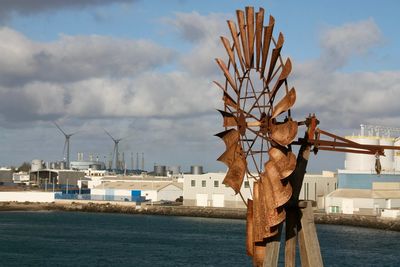 Built structure by sea against sky