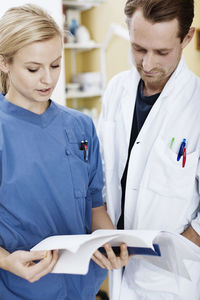 Doctor and nurse reading file in hospital