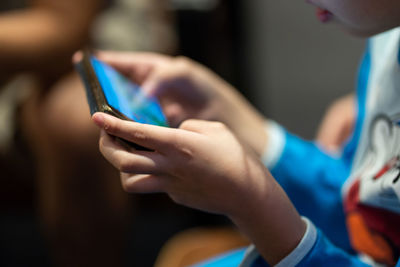Midsection of boy holding mobile phone