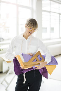 Smiling fashion designer holding textiles