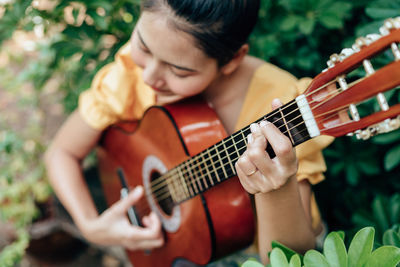 Midsection of man playing guitar