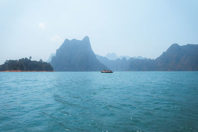 Scenic view of sea and mountains against sky