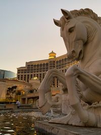 Statue of building in city against sky