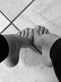 Bare feet tippy-toeing on tile floor 