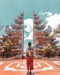 Full length rear view of man standing against building in city