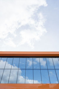 Low angle view of glass building against sky